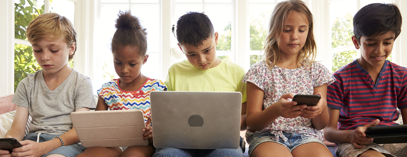 5 Sitting Kids Using Their Electronic Devices